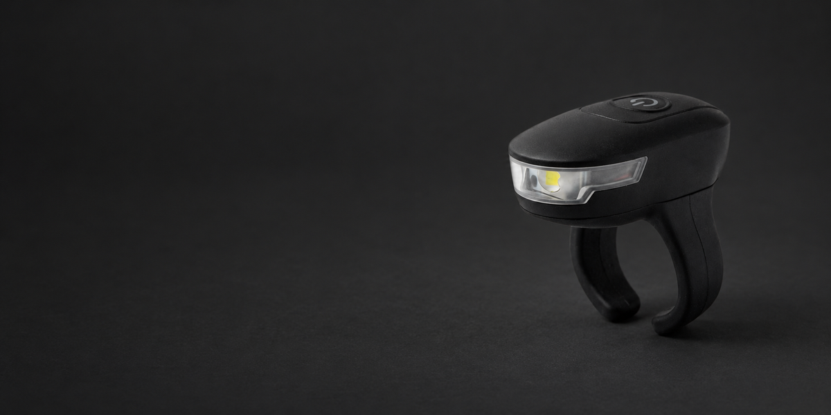 DEX FingerLight showing its front LED lens, top button, and adjustable split ring