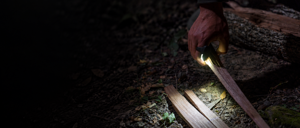 DEX FingerLight illuminating kindling in a camper’s hand after dark
