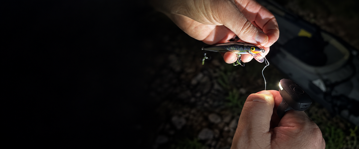 DEX FingerLight illuminating hands tying line to a fishing lure
