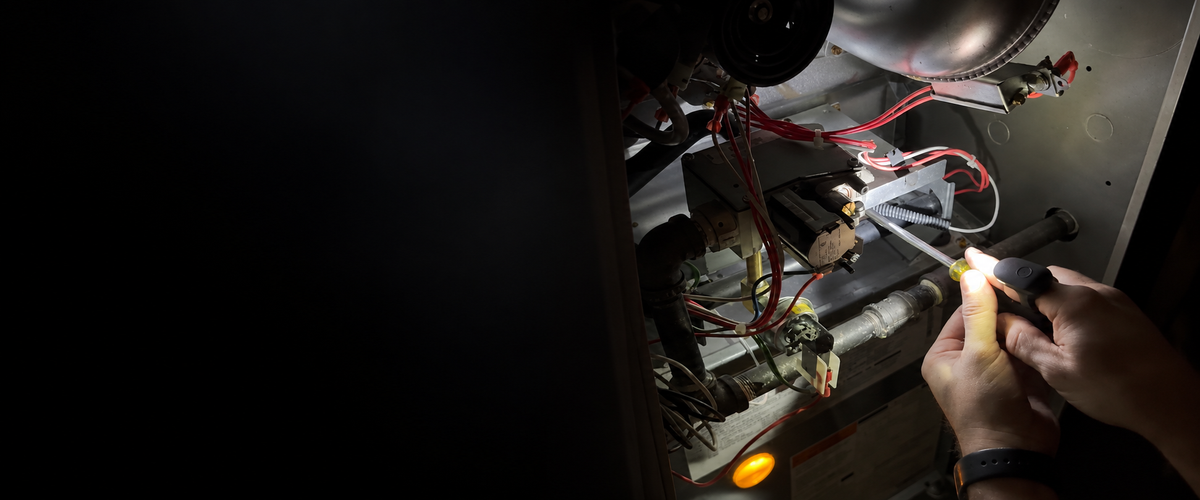 DEX FingerLight illuminating a technician’s hands and furnace components during HVAC work