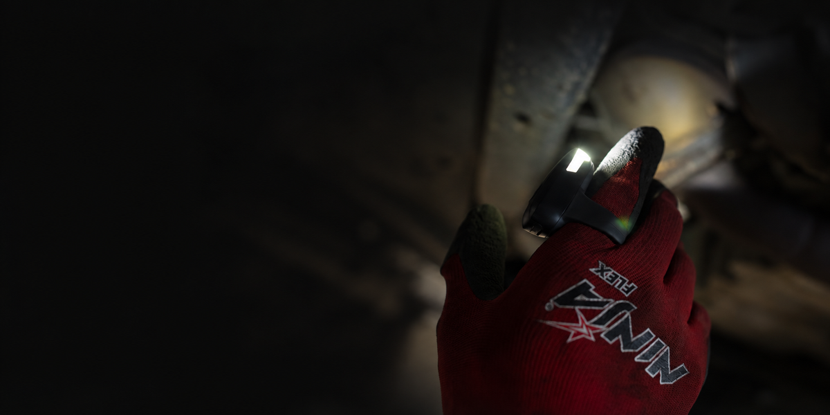DEX FingerLight illuminating vehicle components from a finger on a red work glove