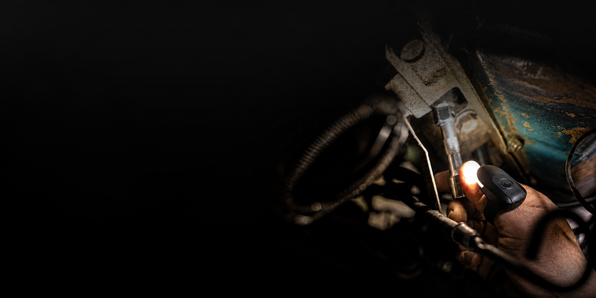 DEX FingerLight lighting a socket and fastener while a hand works under the hood